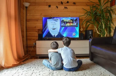 Dos niños mirando el televisor con dos altavoces estéreo
